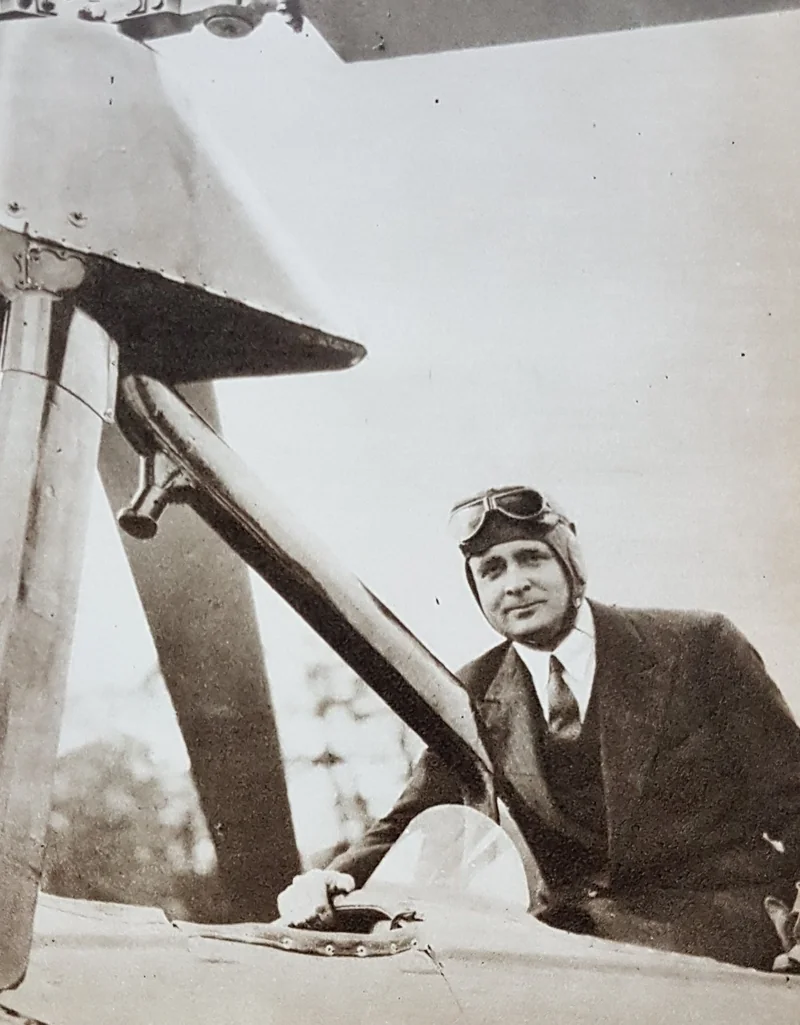 Black-and-white photo of Juan de la Cierva wearing a leather flying helmet and goggles, seated in the cockpit of a Cierva C.30 below the rotor pylon