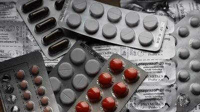 Varios blísteres de pastillas y cápsulas amontonados sobre una mesa
